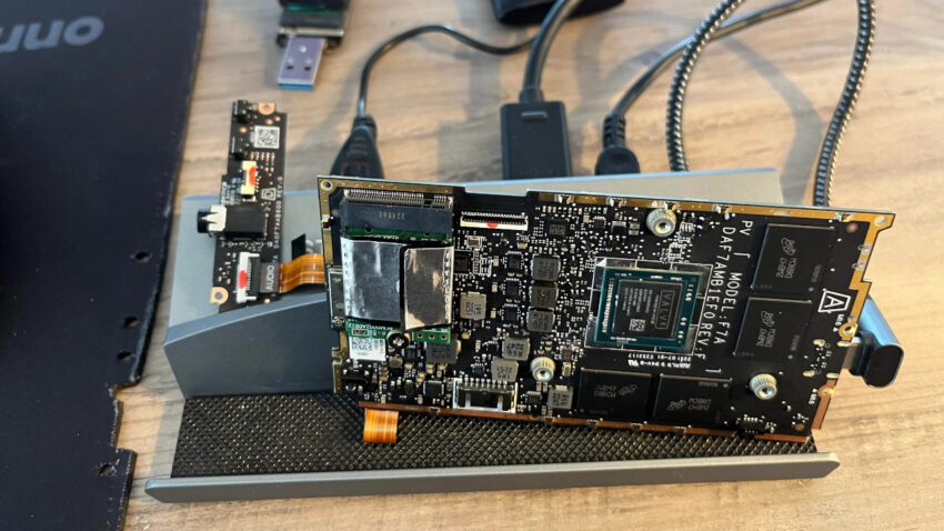 Steamdeck motherboard standing upright propped onto a USB-C dock it's wired up to, showing just how little you need to make the steamdeck board work.